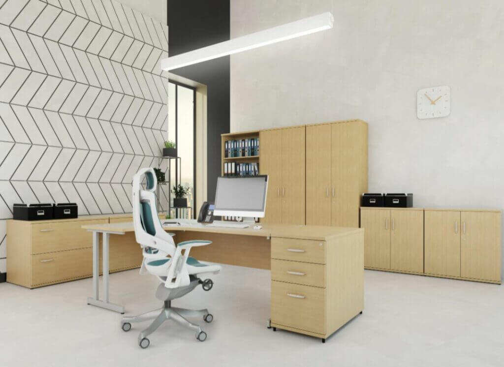 White ergonomic chair set at desk in a large office