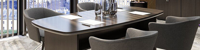 a boardroom with grey chairs and a dark walnut boardroom table