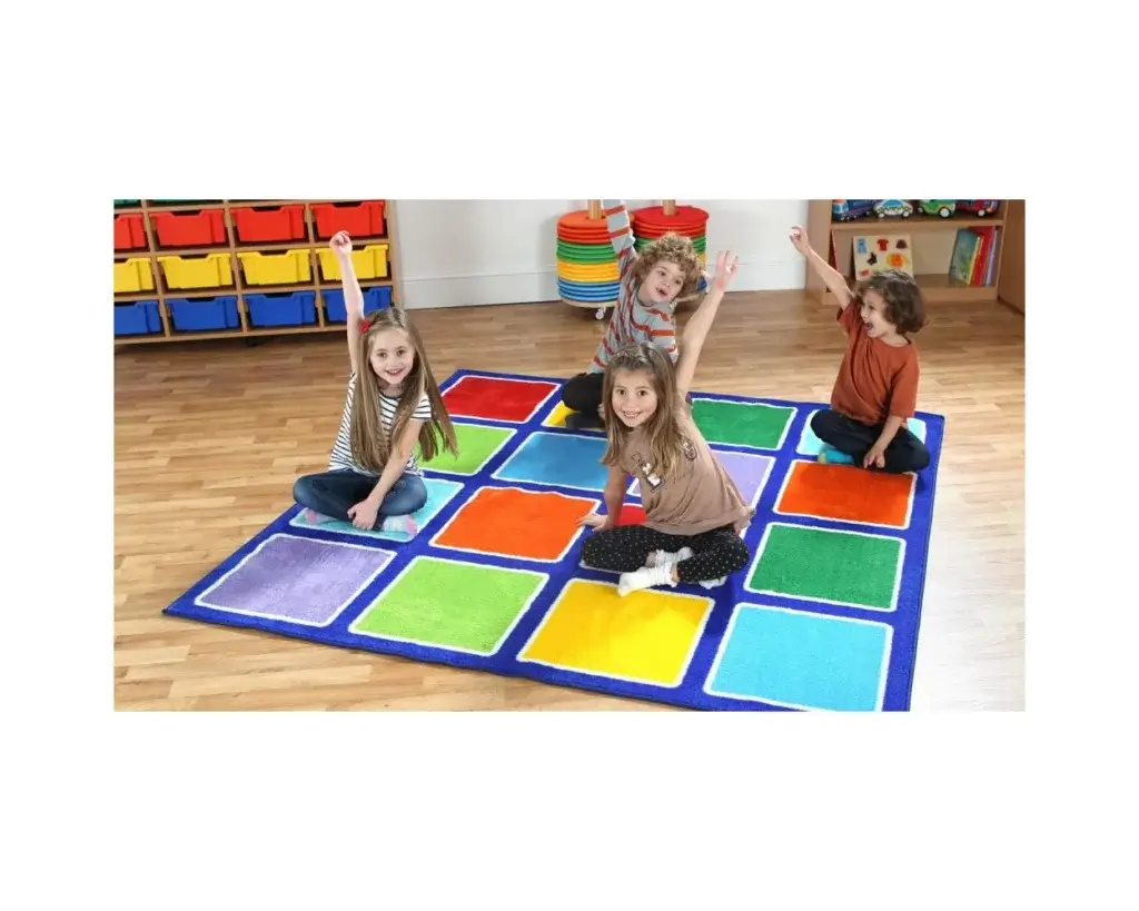 three children sat on a classroom mat that has multiped coloured squares